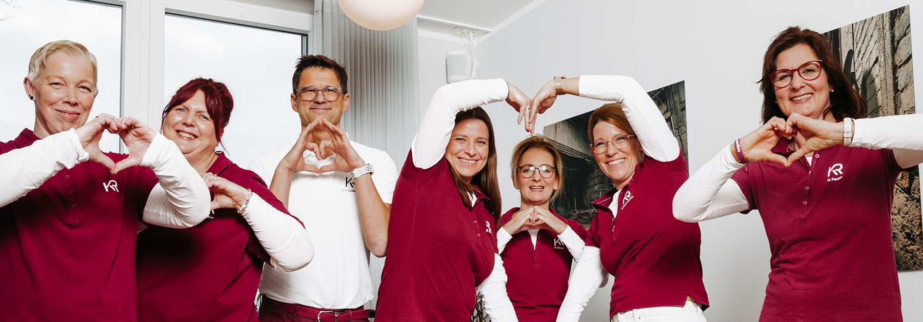 Praxis Team mit Herz Freundliches Praxis Team, Gruppenbild, Hände formen Herz, Gemeinschaft